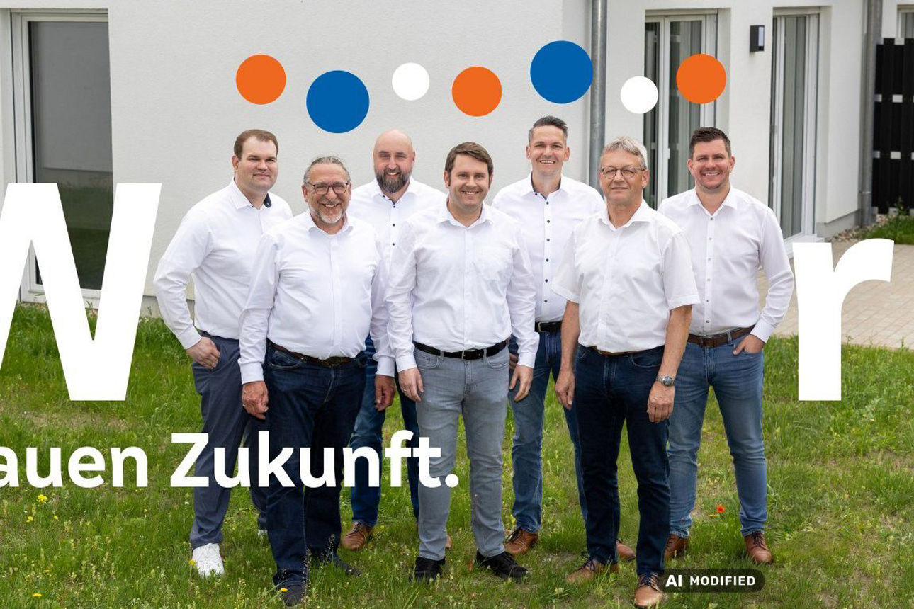 Das Team der Mobilen Baufinanzierungsberater steht vor einem Neubau