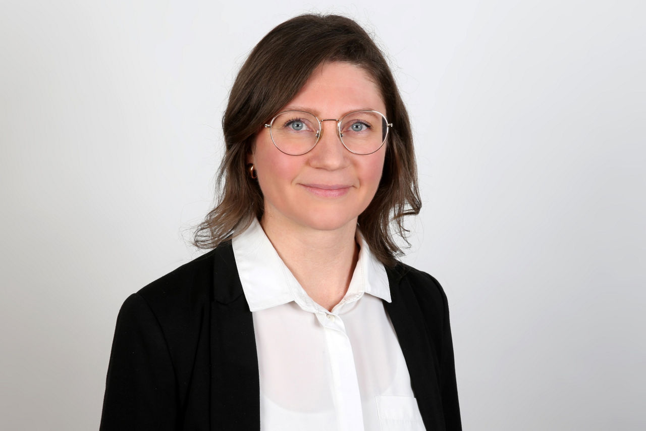 Eine lächelnder Frau schaut in die Kamera.