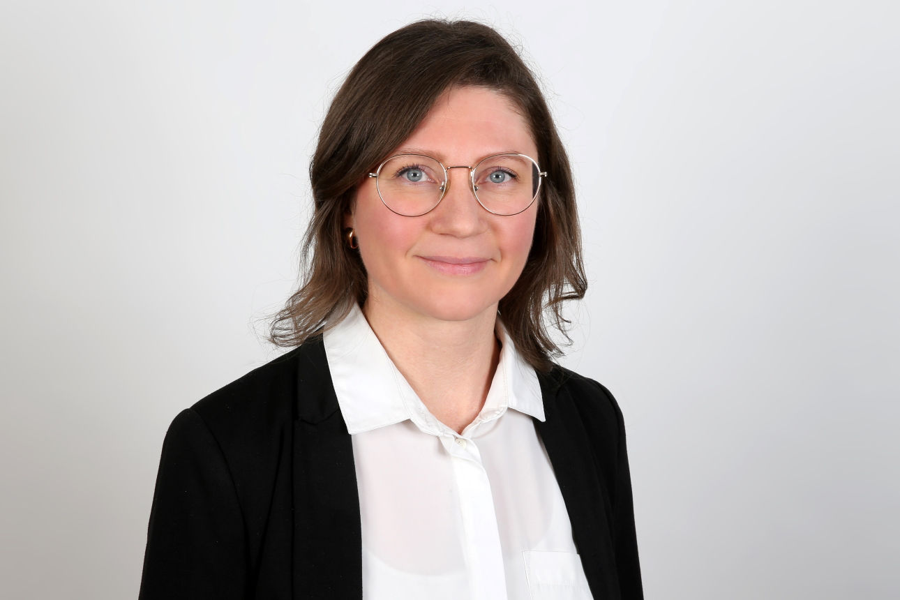 Eine lächelnde Frau schaut in die Kamera.
