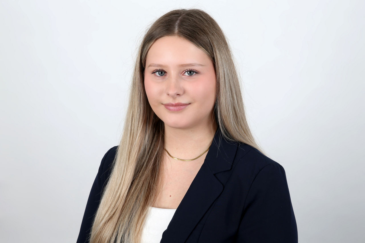 Eine lächelnder Frau schaut in die Kamera.