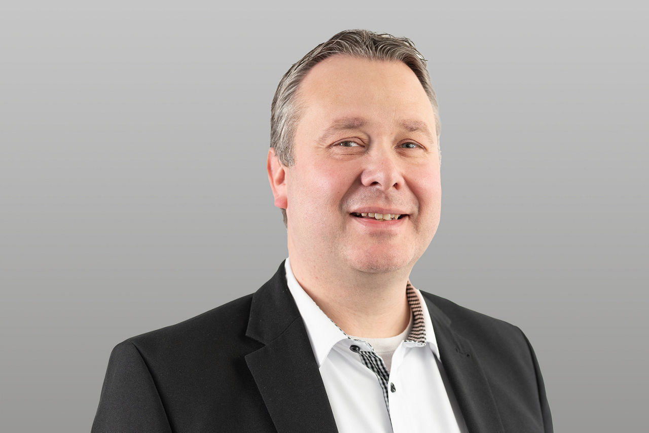 Privatkundenberater Rene Walder vor grauen Hintergrund