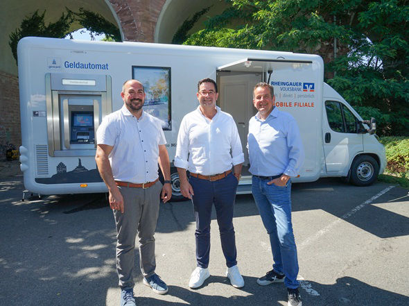Es sind drei Männer vor der mobilen Filiale zu sehen