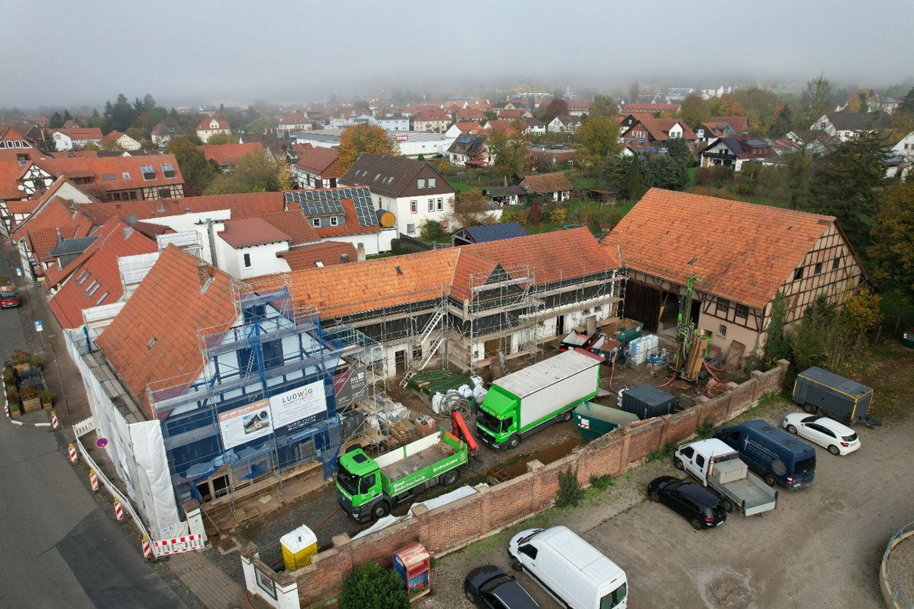 Blick auf die Hofreite mit LKWs vor Ort