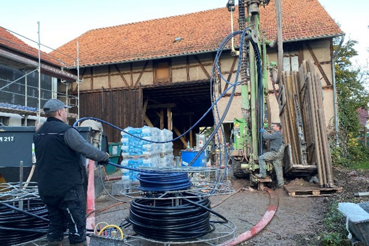 Mann bedient Bohrgerät im Hof