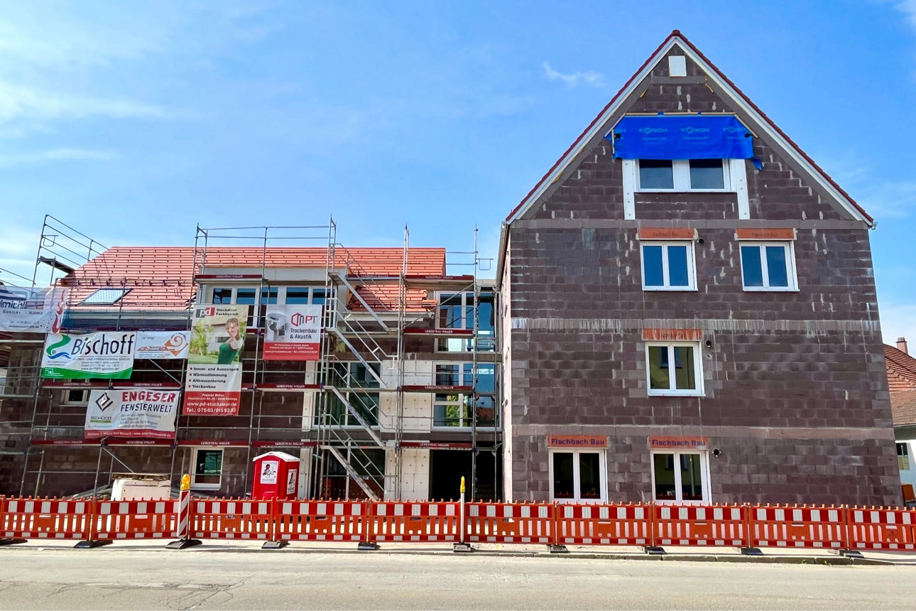 Rohbau eines Mehrfamilienhauses in Wangen im Allgäu. Es sind Baugerüste um das Haus aufgestellt.