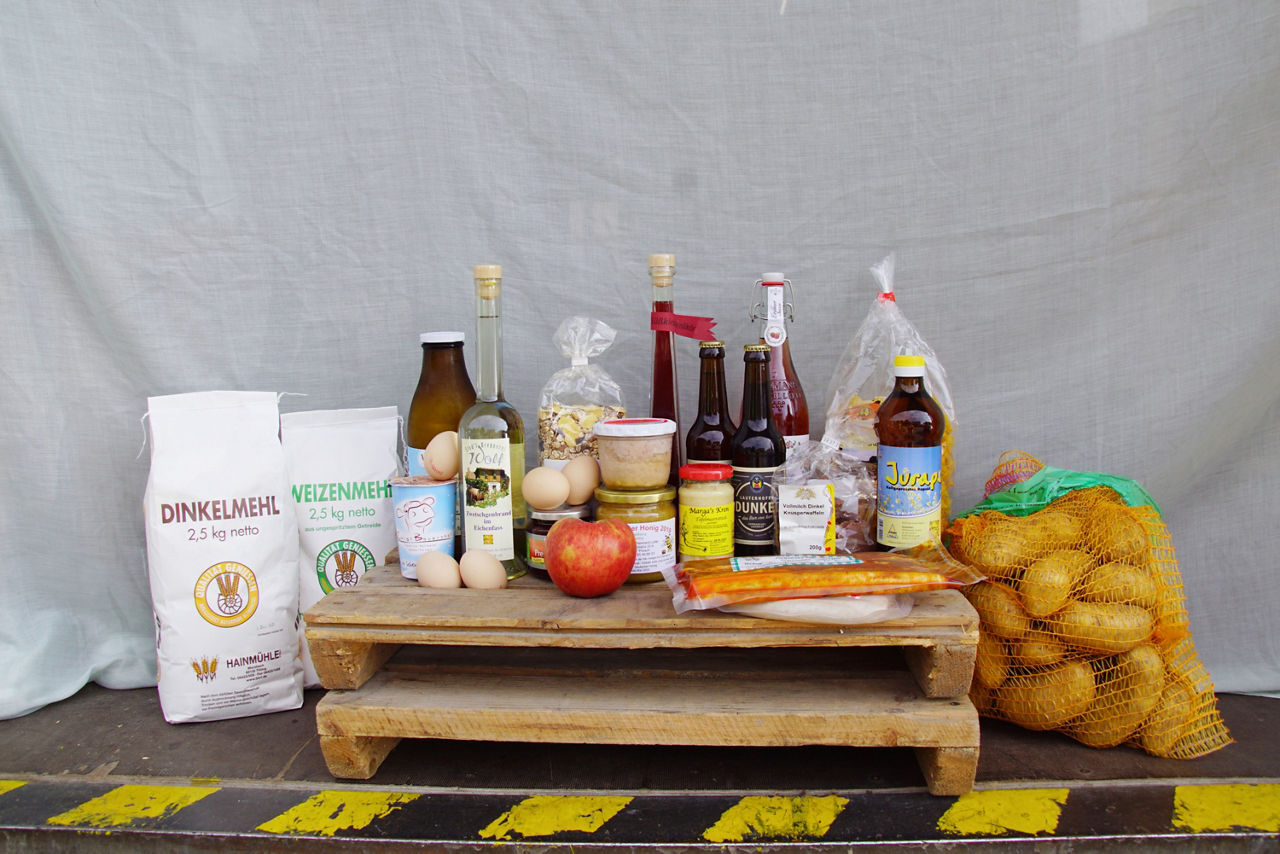 Geschenkkorb mit diversen Lebensmitteln wie Honig, Glühwein, Nudeln und Speck
