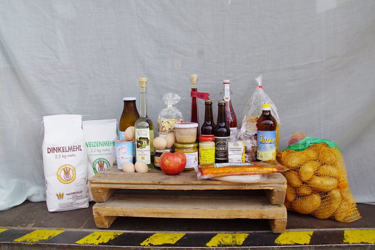 Geschenkkorb mit diversen Lebensmitteln wie Honig, Glühwein, Nudeln und Speck