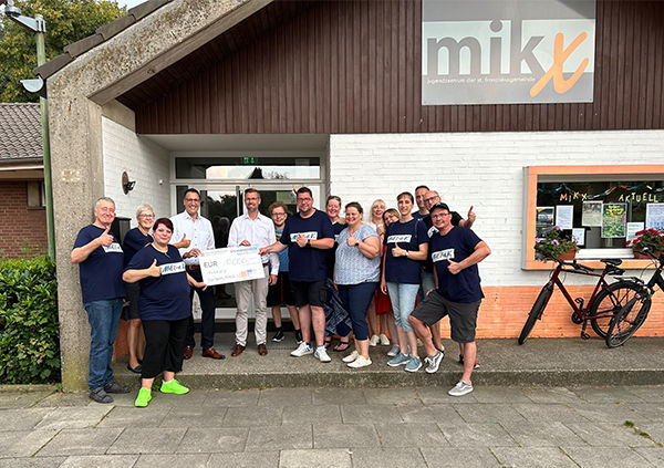 Mitglieder des Mikx-Treffpunkts freuen sich über eine neue Eingangstür und haben einen Scheck in der Hand