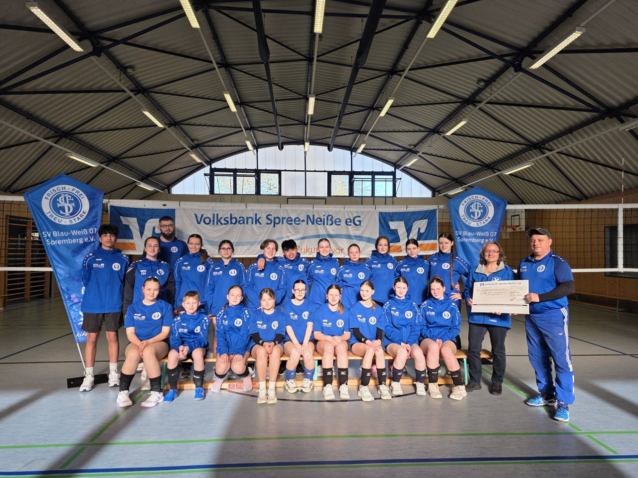 Gruppe von Sportlern vor einem Volleyball-Netz