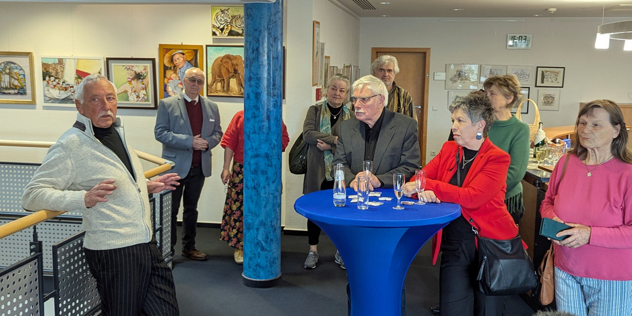 Menschen stehen im Foyer und lauschen den Worten des Malers Manfred Möller