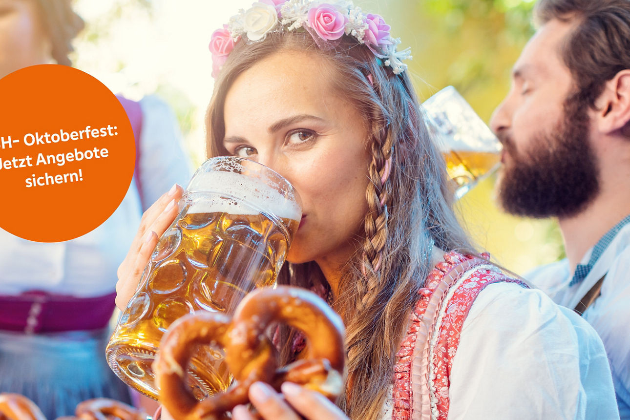 Eine Frau mit Blumen in den Haaren trinkt aus einem Bierkrug und hält eine Brezel in der Hand.