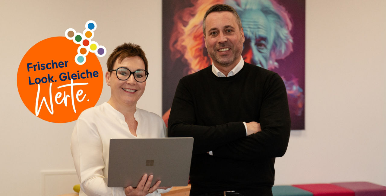 Zwei Personen mit einem Laptop in der Hand. Daneben ein Logo auf dem steht: Frischer Look. Gleiche Werte