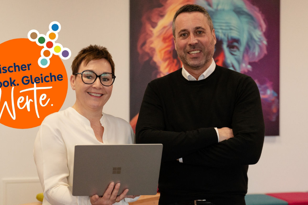 Zwei Personen mit einem Laptop in der Hand. Daneben ein Logo auf dem steht: Frischer Look. Gleiche Werte