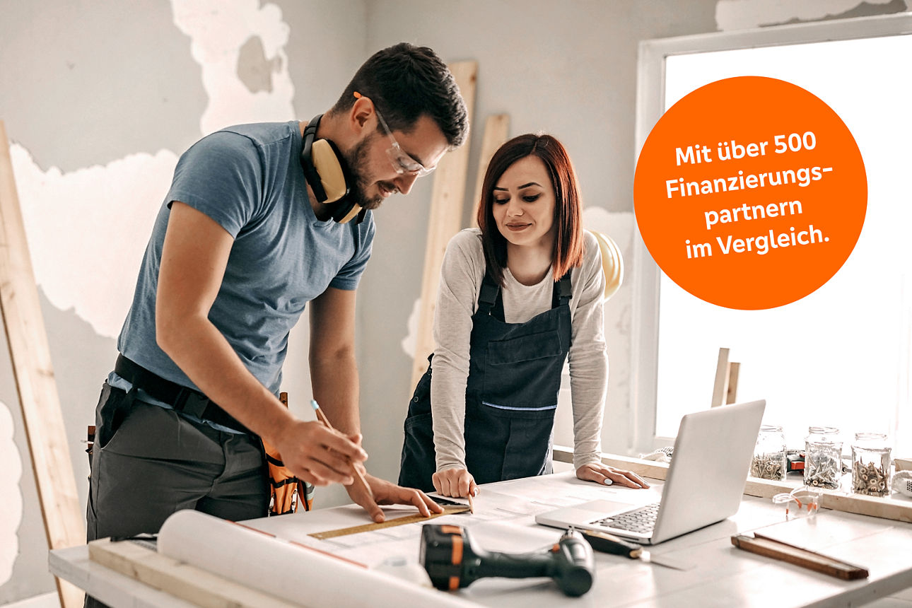 Junges Paar macht schaut sich die Pläne bei der Wohnungsrenovierung an