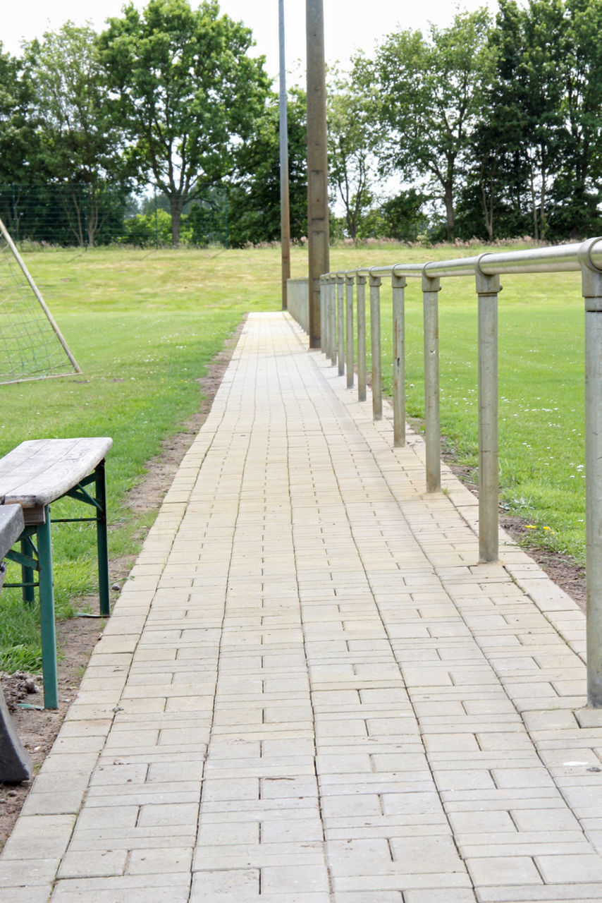 Gepflasterte Weg am Sportplatz 