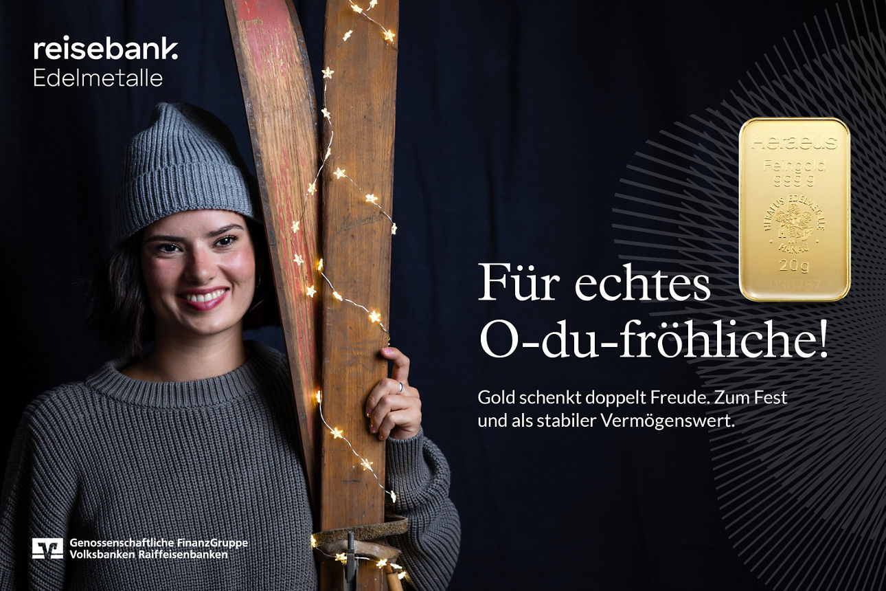 Frau mit Mütze hält beleuchtete Skier; daneben ein Goldbarren und der Text „Für echtes O-du-fröhliche! Gold schenkt doppelt F