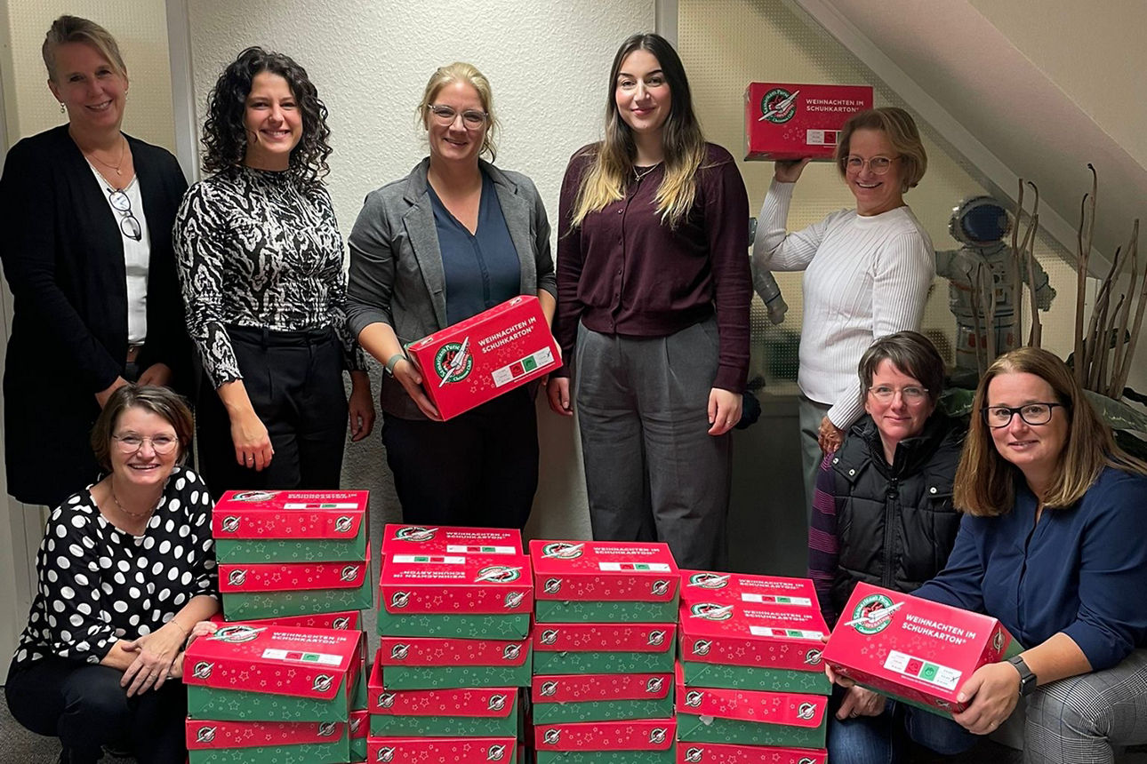 Acht Frauen der Volksbank Schermbeck mit Kartons der Aktion "Weihnachten im Schuhkarton".