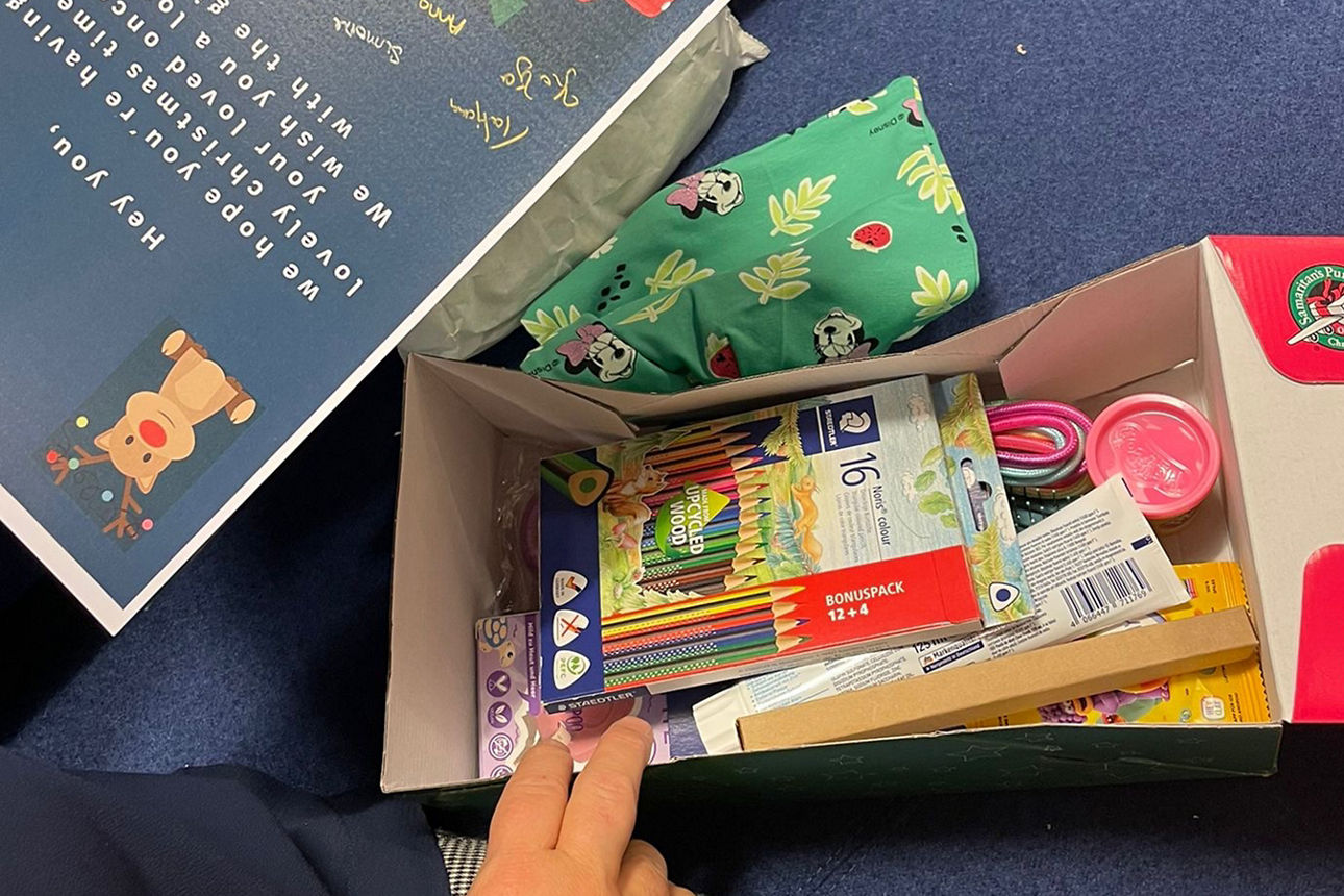 Acht Frauen der Volksbank Schermbeck mit Kartons der Aktion "Weihnachten im Schuhkarton".