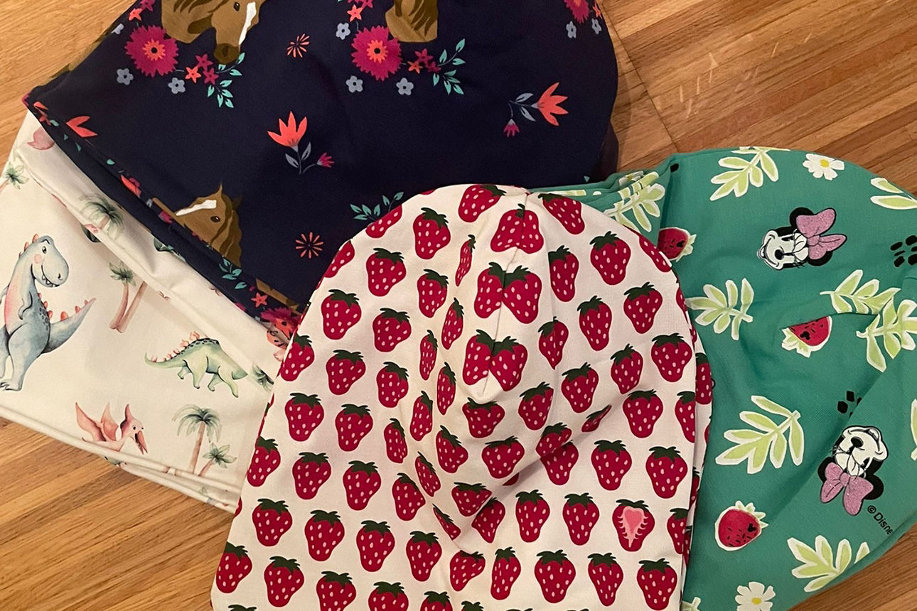 Vier selbstgenähte Kindermützen.