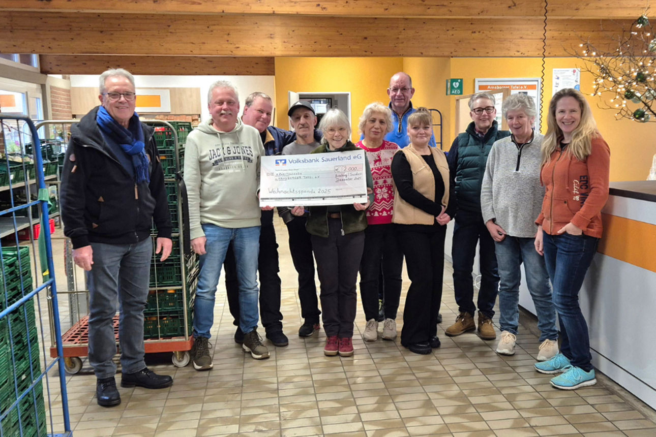 Gruppenfoto der Helfer der Tafel Arnsberg  mit einem Spendencheck