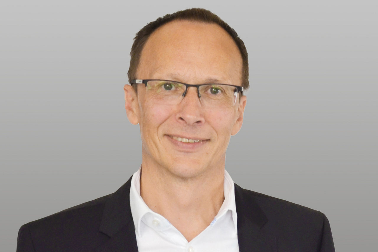Firmenkunden Eric Brühne vor grauem Hintergrund