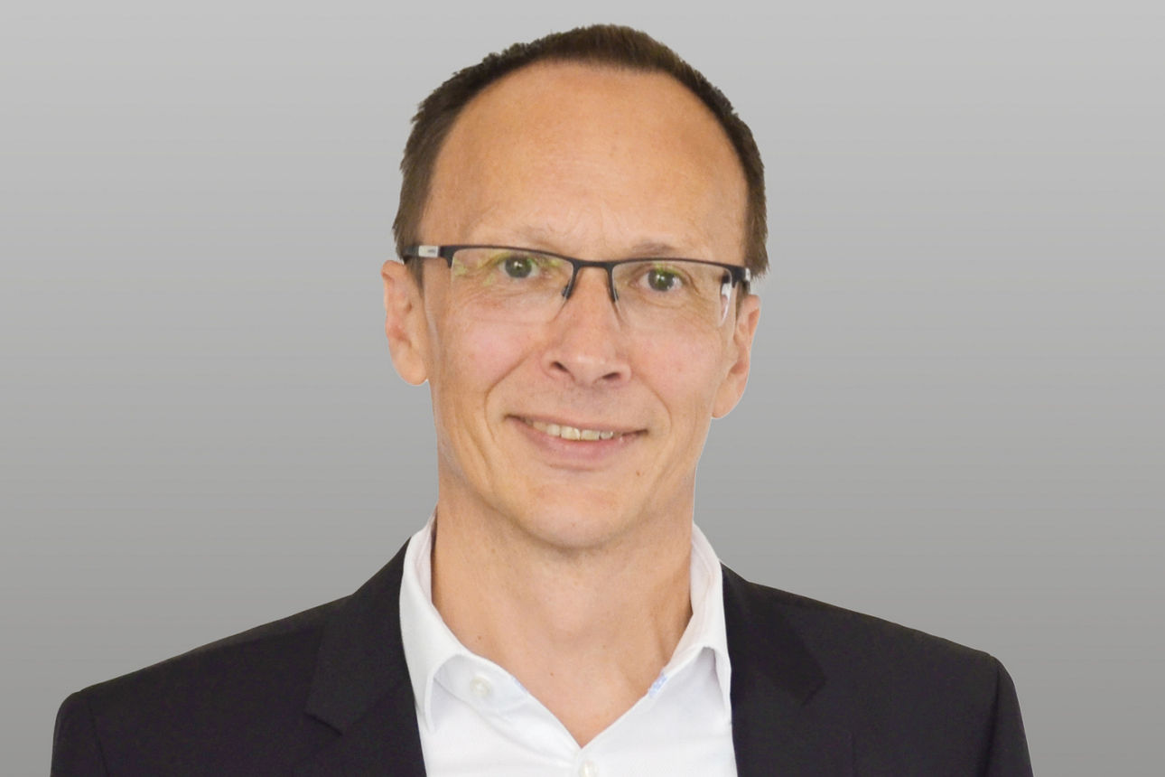 Firmenkunden Eric Brühne vor grauem Hintergrund