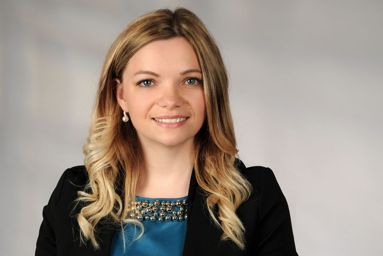 Kristina Kanisch hat blonde lange Haare und eine blaue Bluse mit schwarzem Blazer