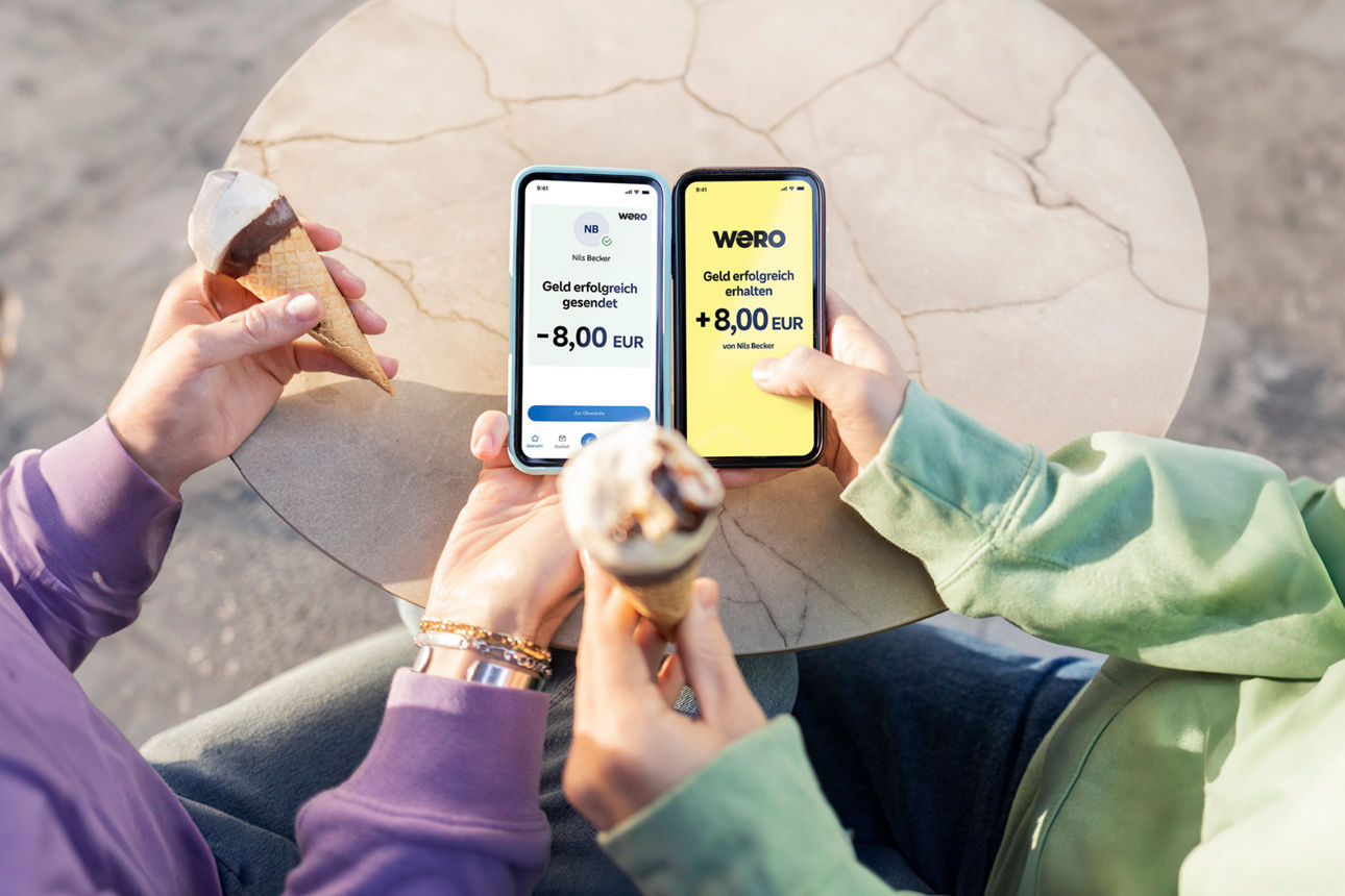 2 Personen mit Eis und Handy in der Hand. Auf den Handys ist Wero geöffnet.