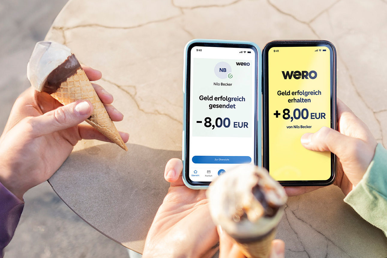 Freunde essen Eis und schicken sich Geld per wero über ihre Smartphones in der Hand