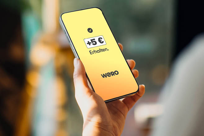 Hand hält Smartphone mit Screen +5 € Erhalten. Wero