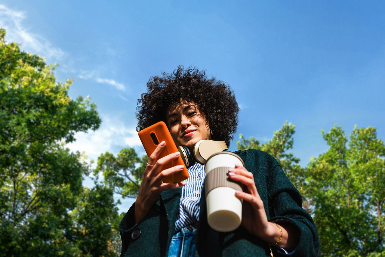 Frau mit Handy in der Hand in der freien Natur  