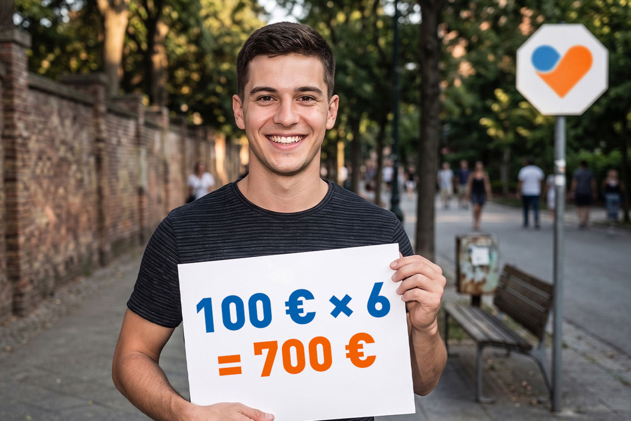 Ein junger, lächelnder Mann mit einem Schild mit der Rechnung 100 € mal 6 gleich 700 € in den Händen