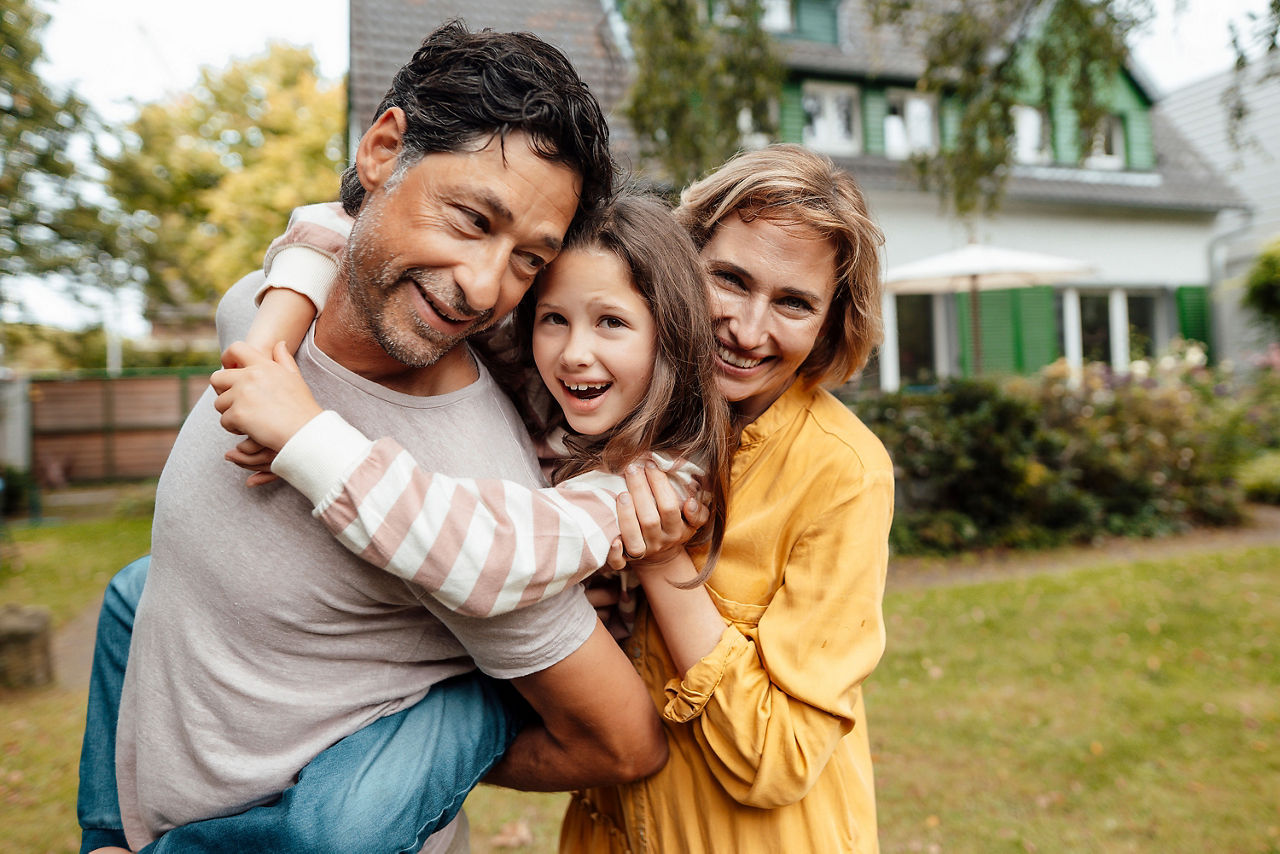 Eine fröhliche Familie im Garten vor ihrem Haus