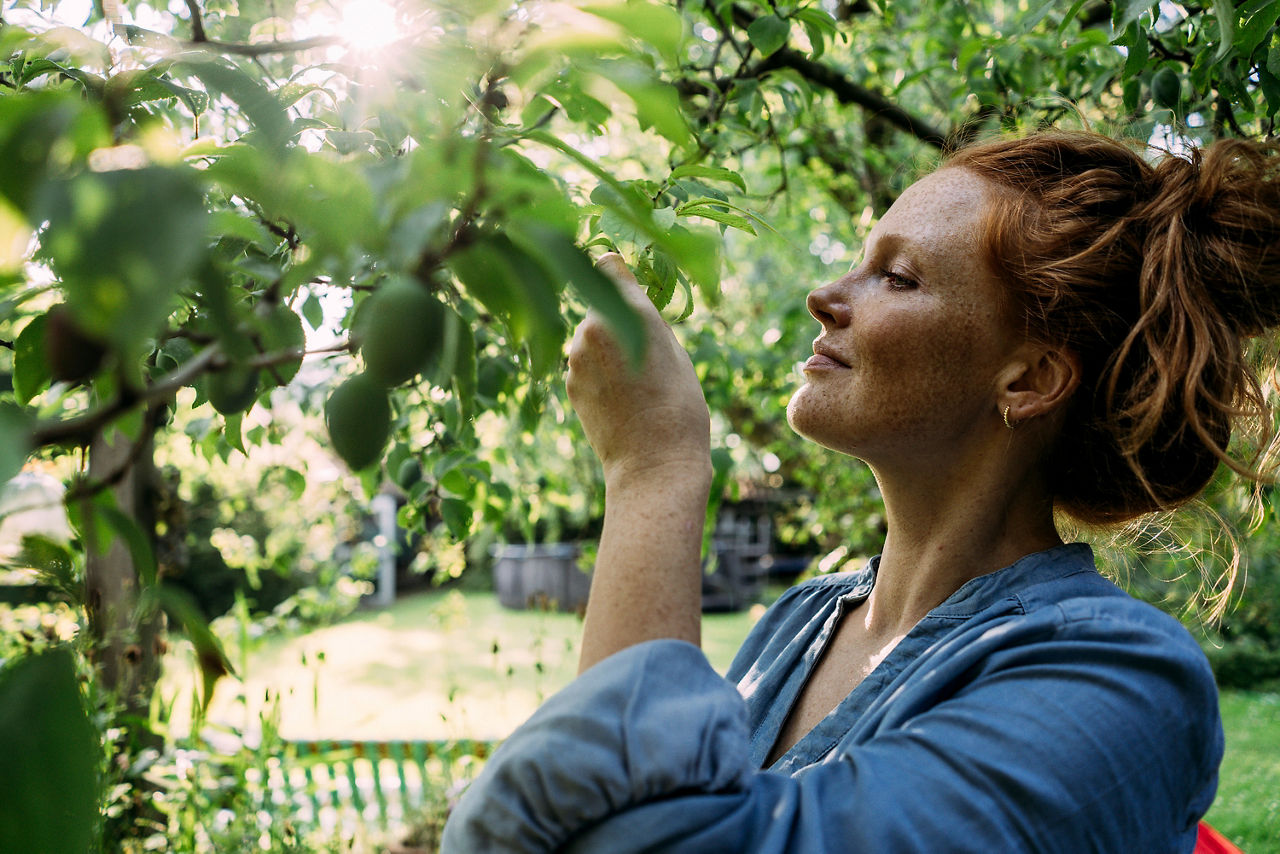 Rothaarige Frau verbringt ihre Freizeit im Garten