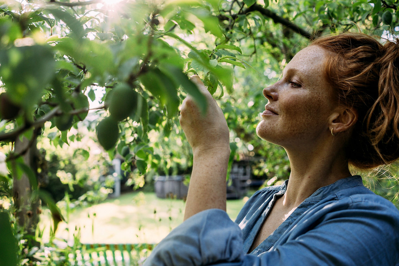 Rothaarige Frau verbringt ihre Freizeit im Garten