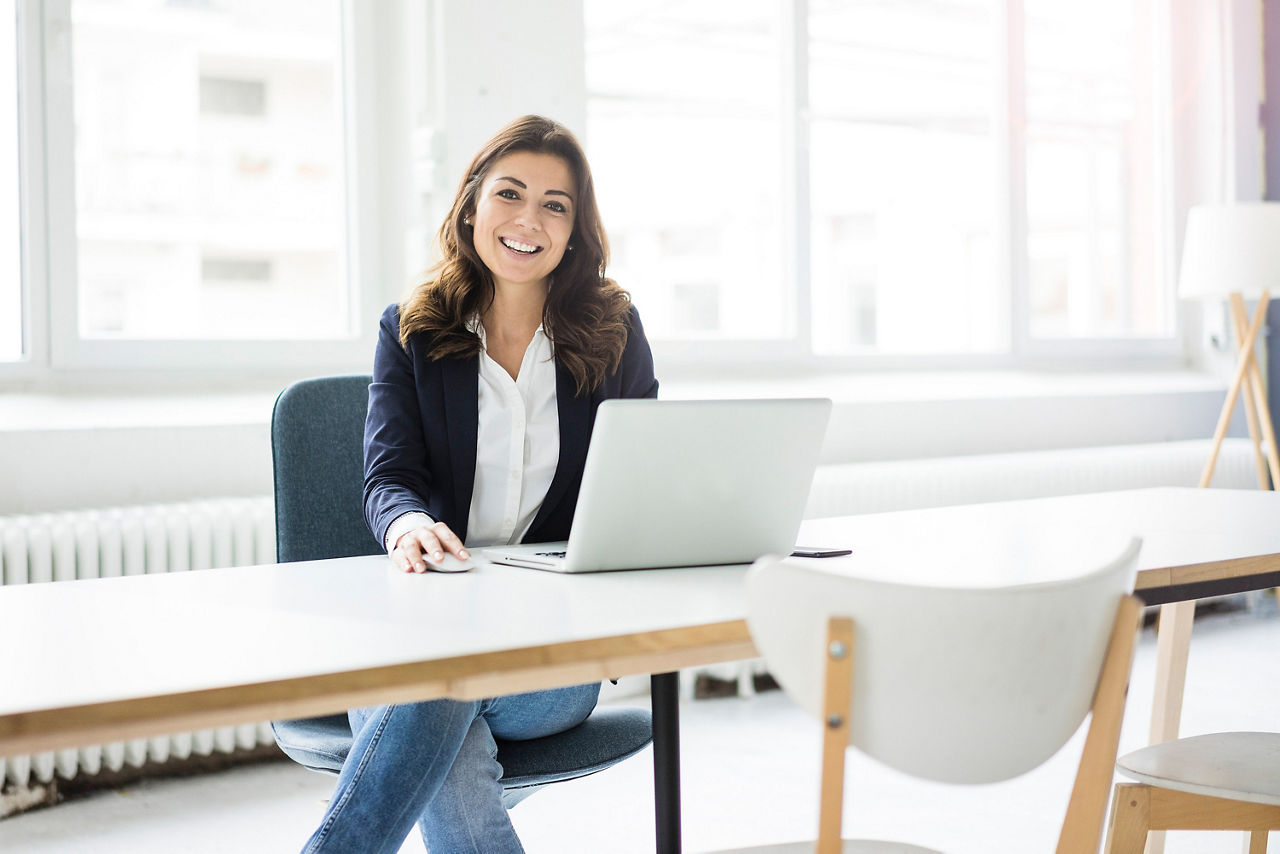 Eine Frau arbeitet in einem Büro an einem Laptop