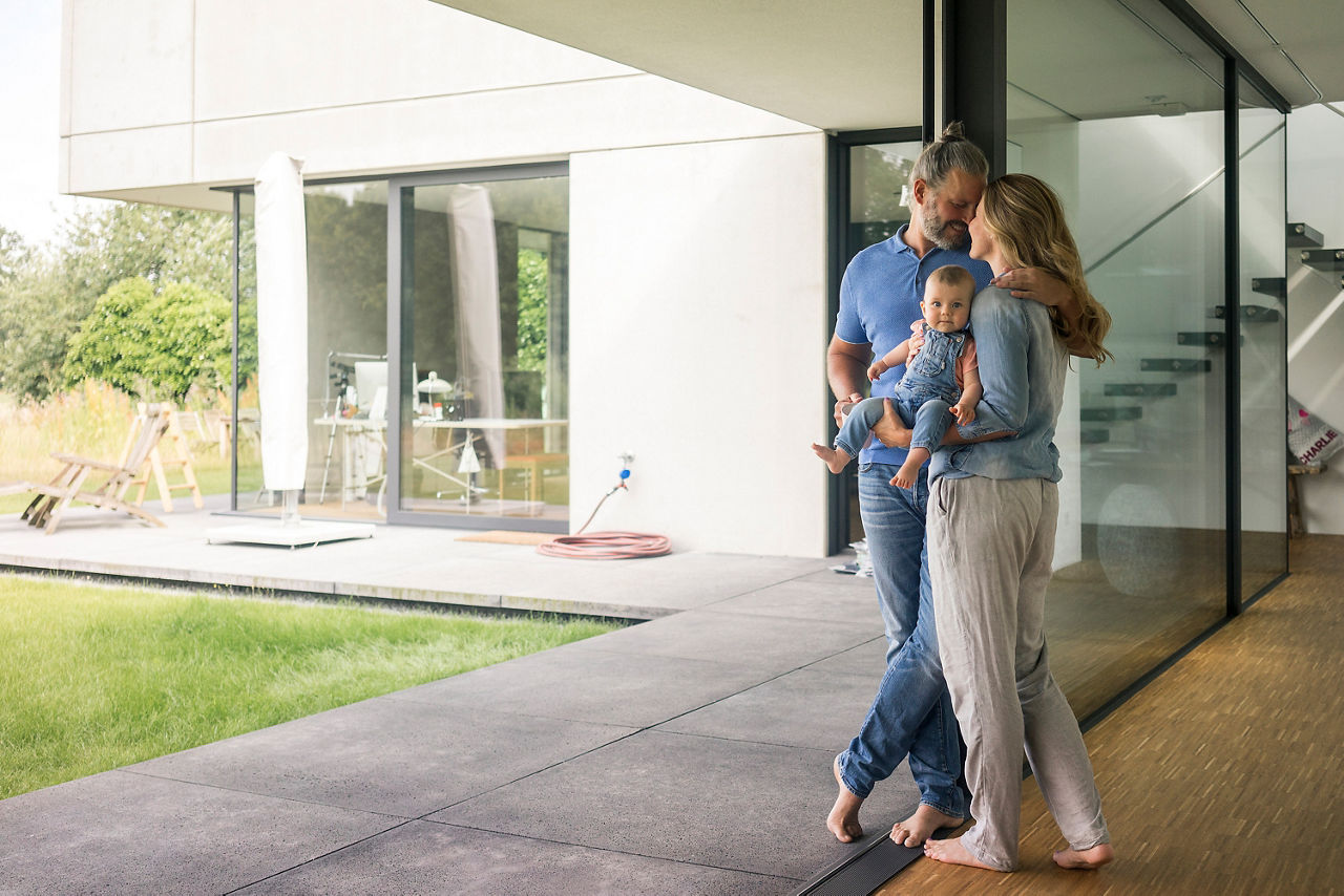 Dreiköpfige Familie, die zu Hause am Fenster steht
