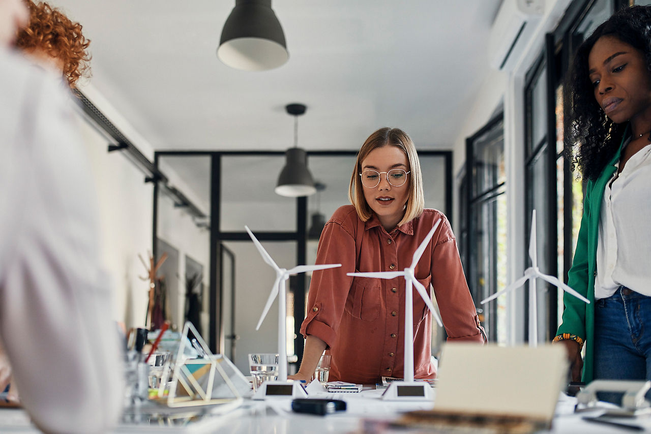 Zwei Frauen im Büro vor Modell-Windrädern