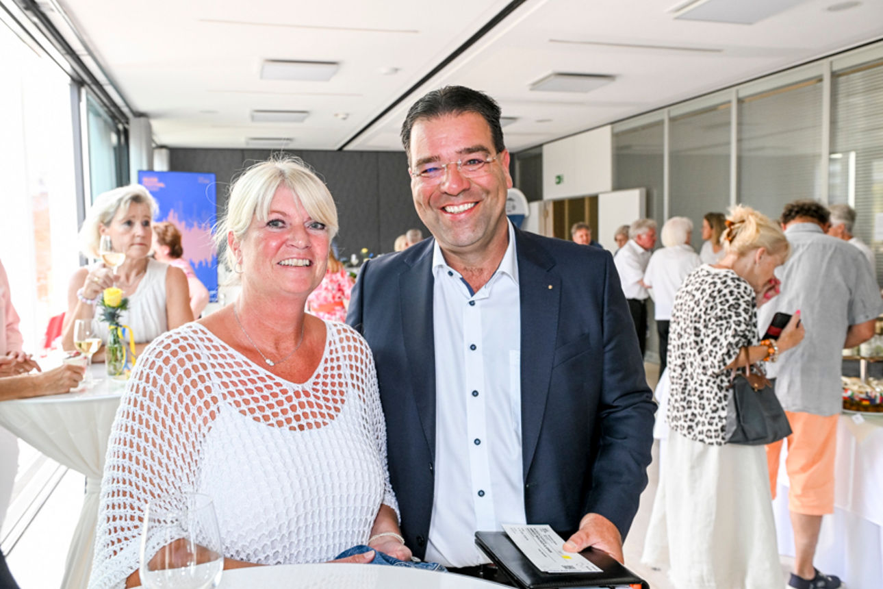 Eine Frau und ein Mann lachen in die Kamera