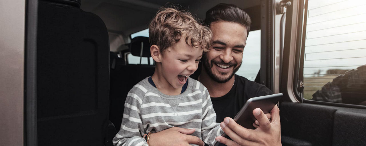 Ein Vater zeigt seinem Sohn etwas auf dem Mobiltelefon