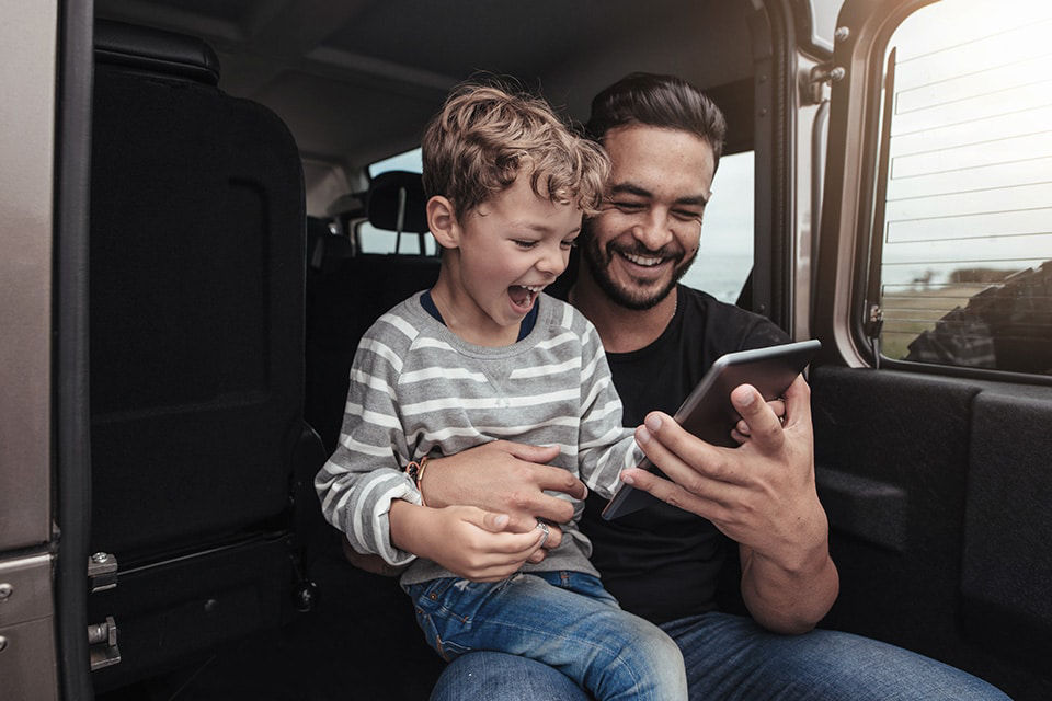 Ein Vater zeigt seinem Sohn etwas auf dem Mobiltelefon