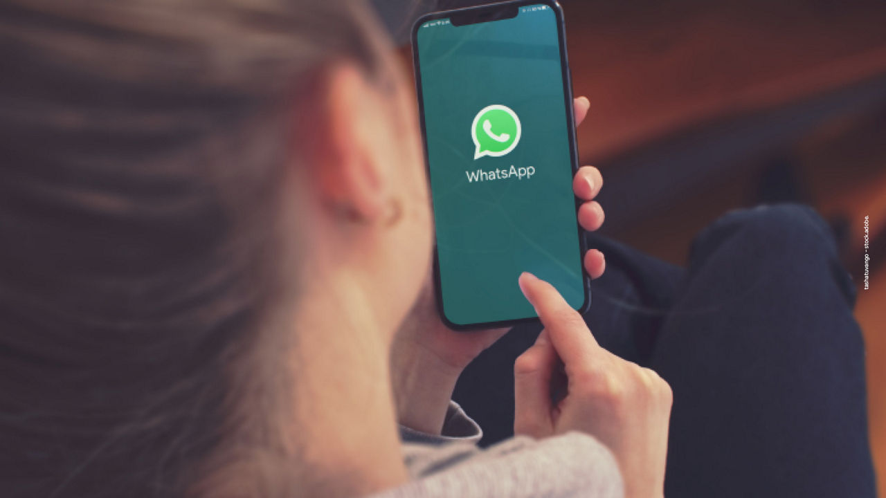 Frau mit einem Handy, auf dem sie gerade eine WhatsApp Nachricht schreibt