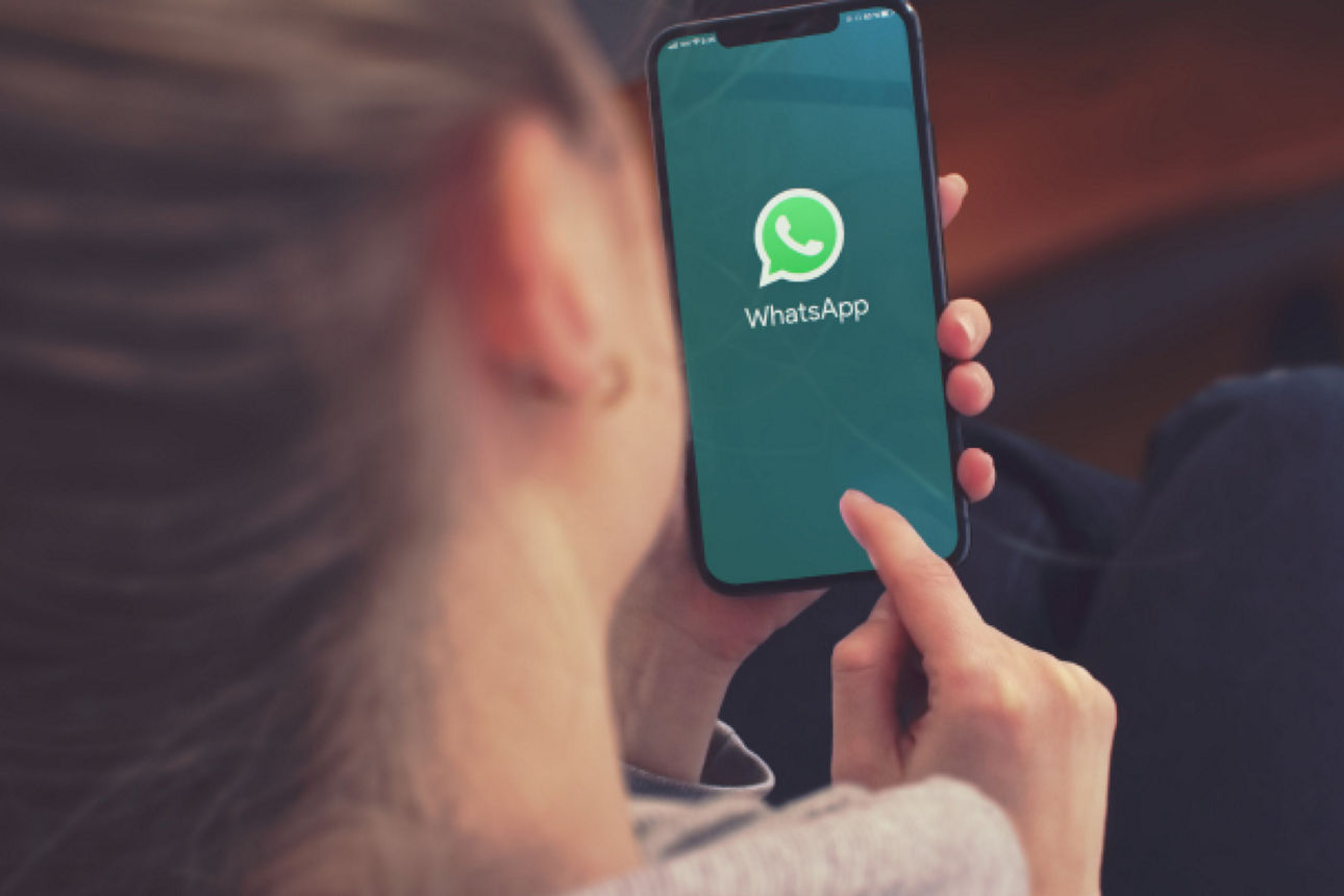 Frau mit einem Handy, auf dem sie gerade eine WhatsApp Nachricht schreibt