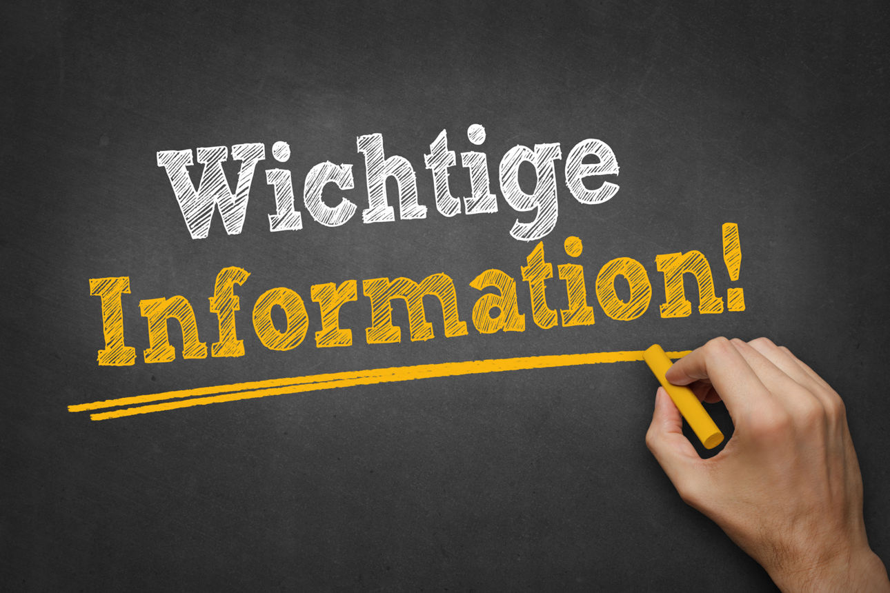 Hand schreibt Text "Wichtige Information" auf Kreidetafel