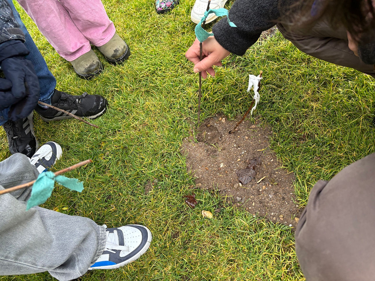 Eine Fahne markiert Spuren im Boden. Nahaufnahme der Füße mit Fahne.