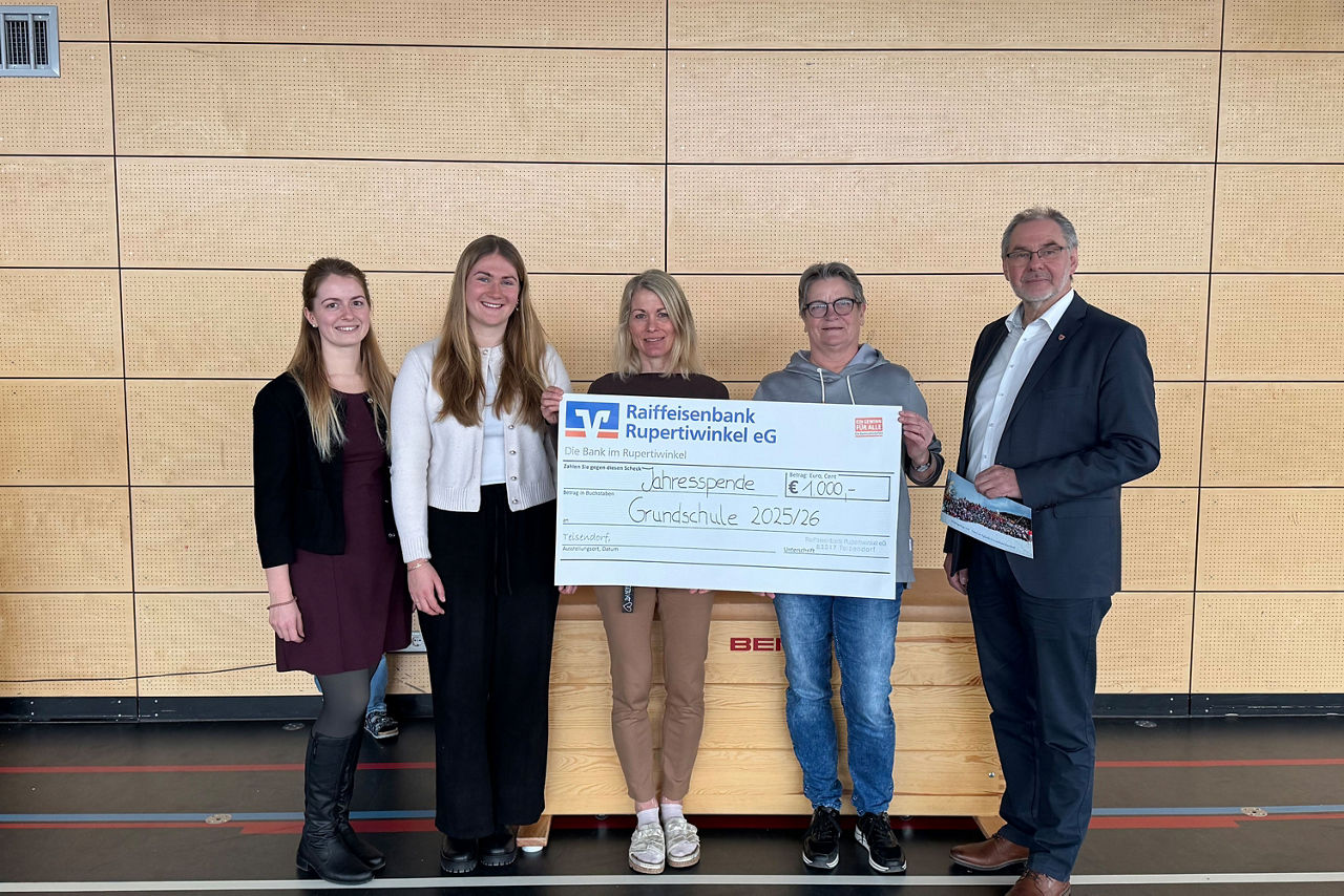 Vier Frauen und ein Mann bei einer Scheckübergabe. Zwei Frauen halten den Spendenscheck in den Händen.