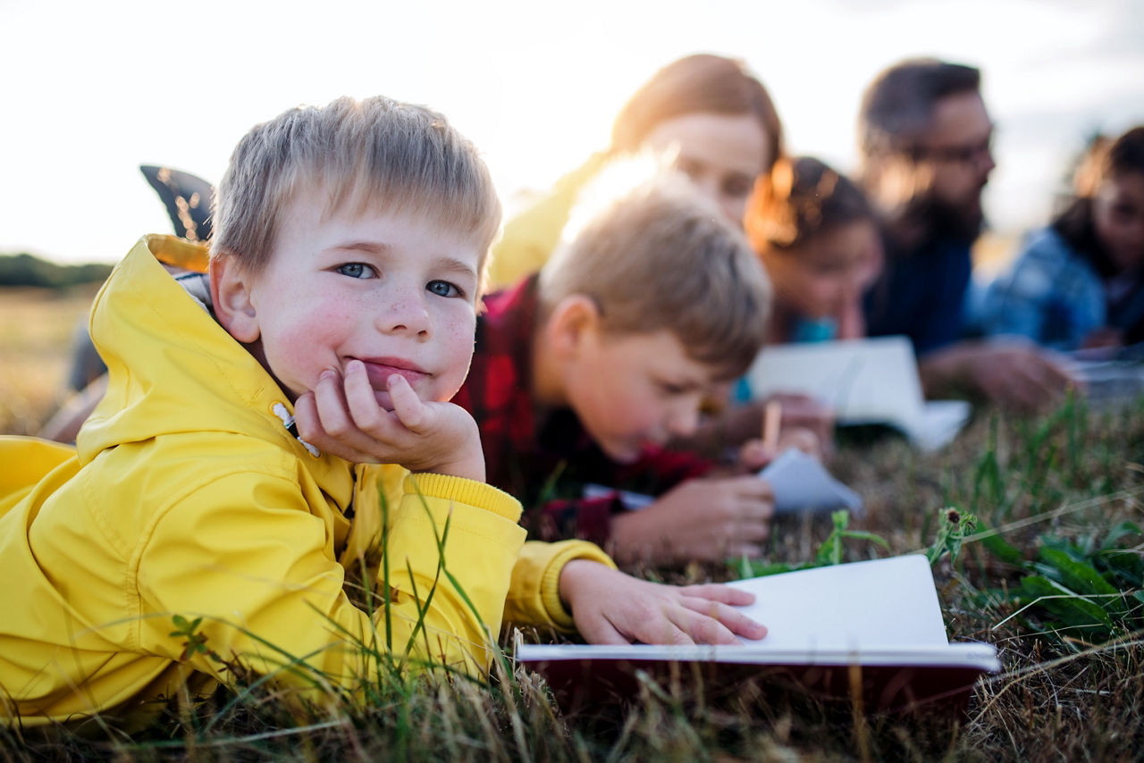 Kinder liegen auf einer Wiese 