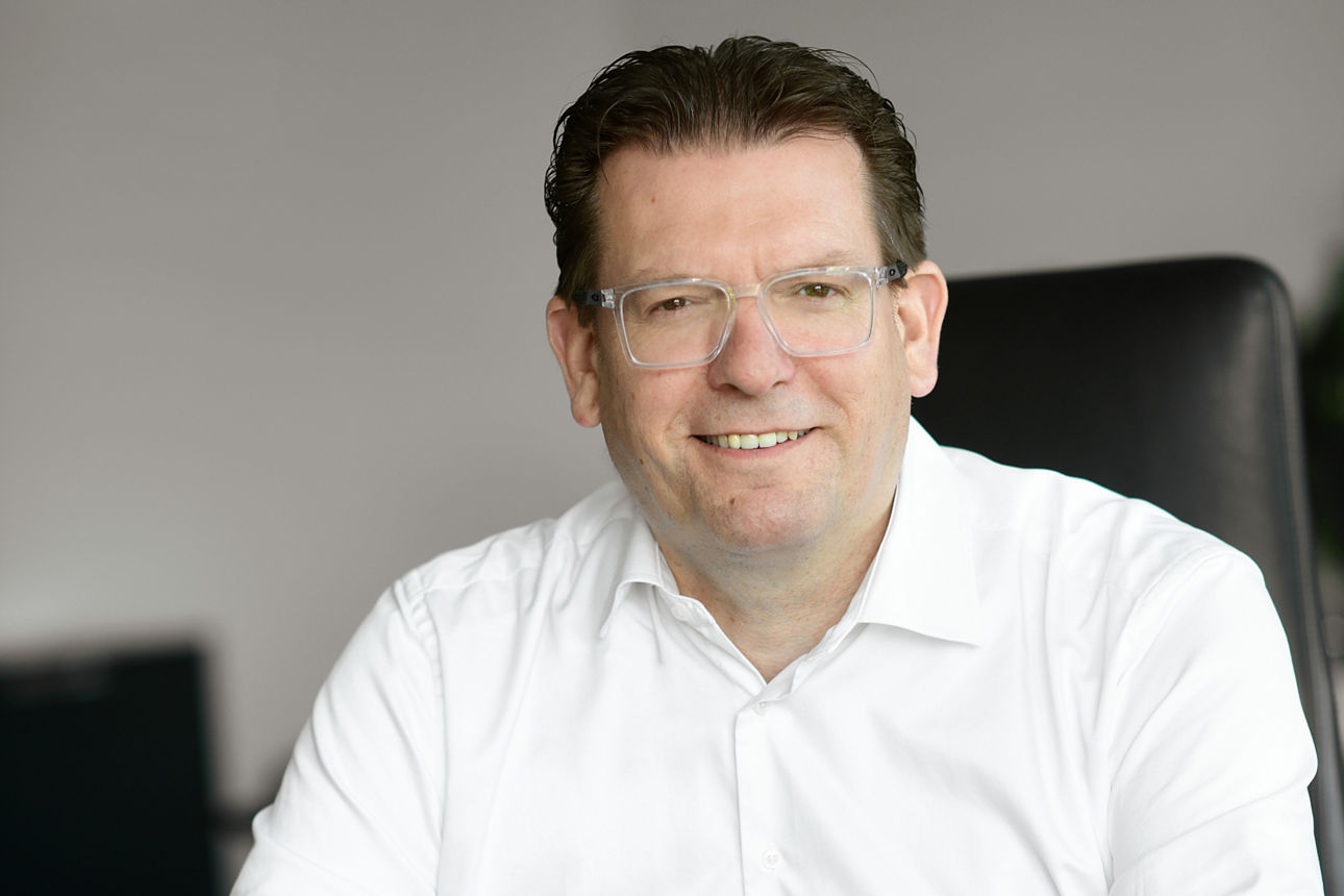 Ingo Hinzmann - Vorstand Vereinte Volksbank - sitzend am Schreibtisch