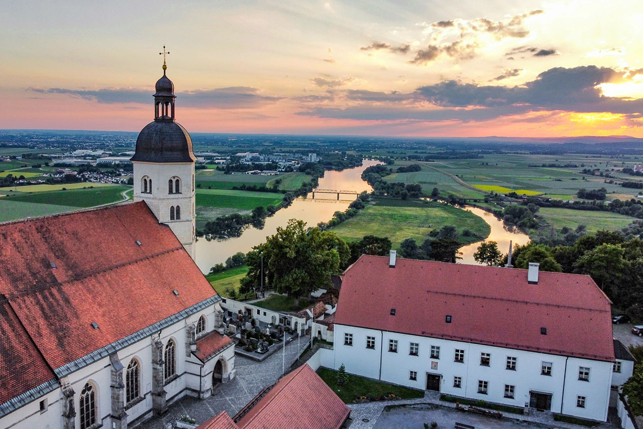 Ein Bild einer Kleinstadt in Bayern mit grüner Hintergrundkulisse. Man sieht einen Kirchturm.