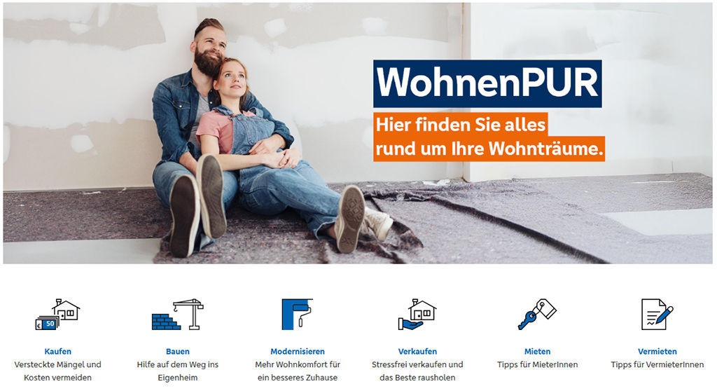 Junges Paar sitzt vor unverputzter Wand und schaut in die Ferne